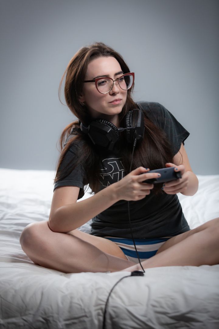 Model Bri plays video games in black and white striped underwear and a classic Star Wars shirt.